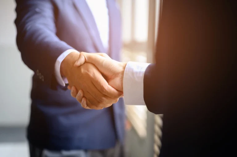 two-businessmen-join-hands-business-cooperation